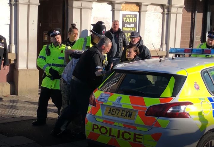 A man is bundled away by police to protect him from the angry after he disrupted a silent tribute with fireworks at a Remembrance Sunday event at the cenotaph in Eccles, Salford.