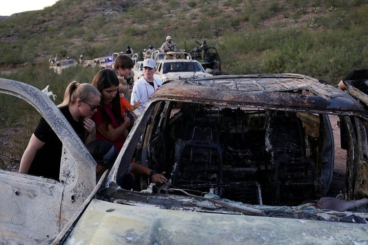 Relatives of slain members of Mexican-American families belonging to Mormon communities observe the burnt wreckage of a vehicle where some of their relatives died, in Bavispe, Sonora state, Mexico November 5, 2019. REUTERS/Jose Luis Gonzalez