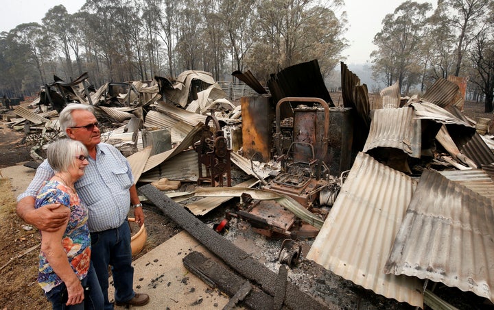 Lyn and Peter Iverson with their burnt out office and shed on their property at Half Chain road, Koorainghat. 