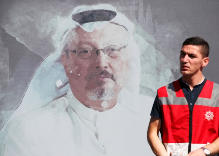 A Turkish police officer walks past a picture of slain Saudi journalist Jamal Khashoggi, near the Saudi Arabia consulate in Istanbul, where he was killed just over a year ago 