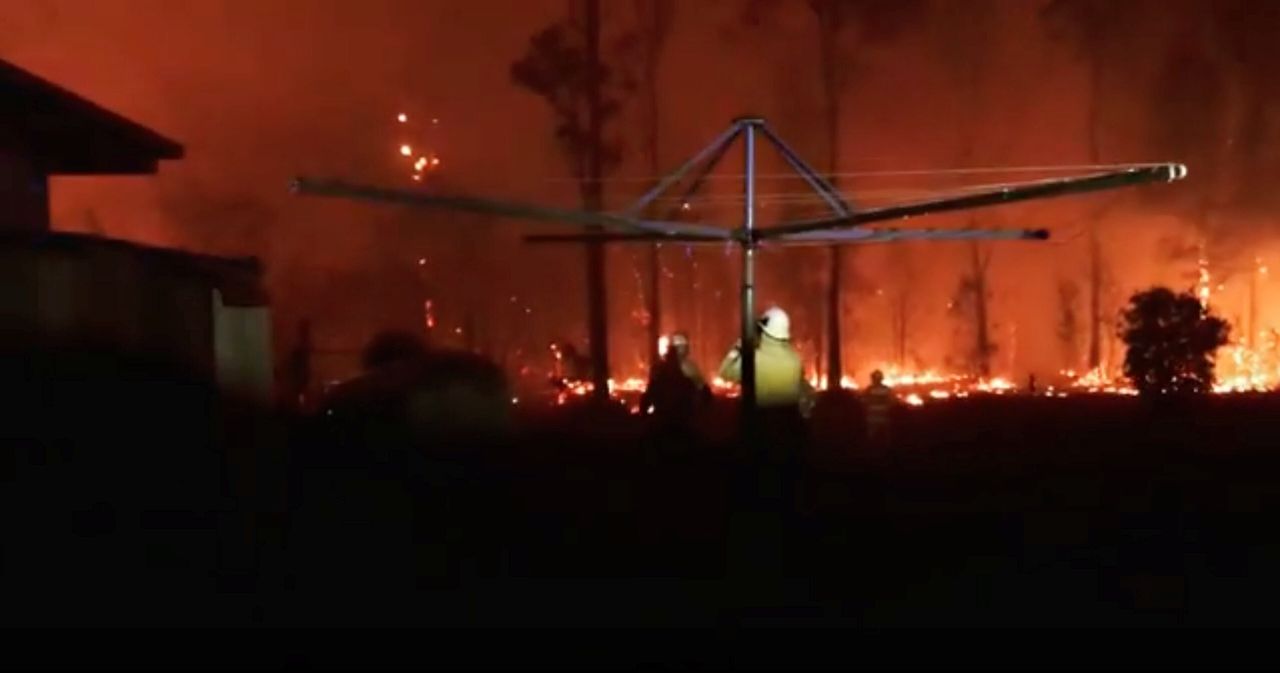 Firefighters look as a fire rages on in Rainbow Flat, New South Wales.