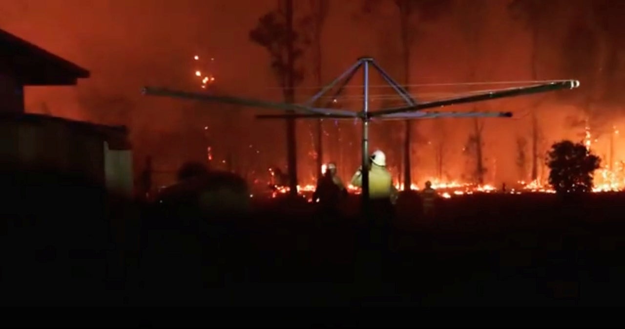 Firefighters look as a fire rages on in Rainbow Flat, New South Wales.