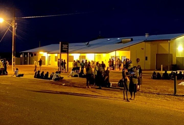 Yuendumu community members gather peacefully outside the police station after the fatal shooting of 19-year-old Kumanjayi Walker on Saturday.