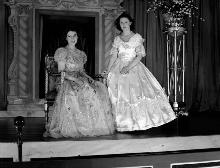 Princesses Margaret and the future Queen Elizabeth wearing elaborate dresses for "Old Mother Red Riding Boots," a Christmas pantomime they performed in at Windsor Castle.