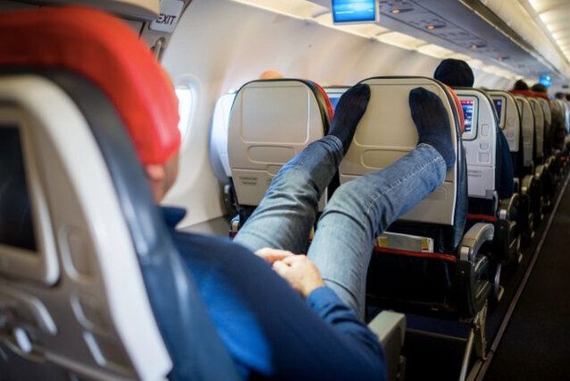 機内で靴を脱いでくつろぐ乗客 イメージ写真
