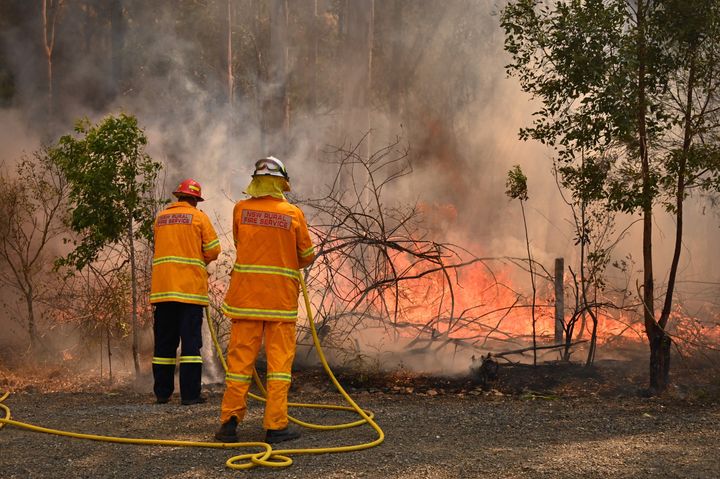 Firefighters tackle a bushfire to save a home in Taree, north of Sydney, on Saturday.