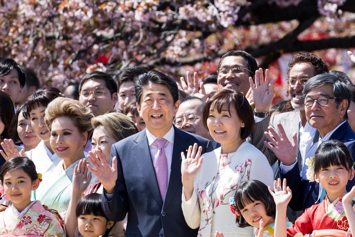 TOKYO, JAPAN - APRIL 13: Japan's Prime Minister Shinzo Abe (C-L) and his wife Akie (C-R) pose for photographs with guest attendees during the cherry blossom viewing party at the Shinjuku Gyoen National Garden on April 13, 2019 in Tokyo, Japan. (Photo by Tomohiro Ohsumi/Getty Images)