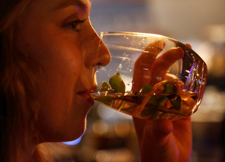 Elsabe Hanekom takes part in a gin tasting session at the Botlierskop Private Game Reserve, near Mossel Bay, South Africa, Monday, Oct. 23, 2019. After about five sizeable bags of dung are collected for a batch of 3,000 to 4,000 bottles of the gin, the droppings are dried and crumbled, then washed to remove dirt and sand. Eventually only the remains of the fruits, flowers, leaves and bark eaten by the elephants are left behind. (AP Photo/Denis Farrell)