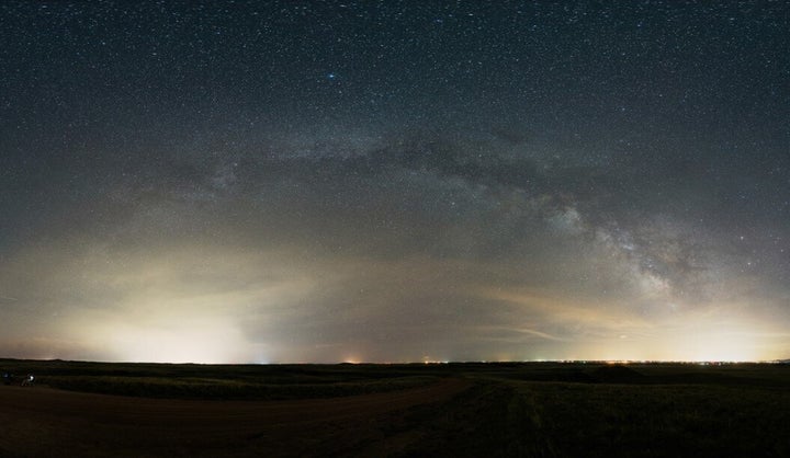 Seen from miles away, bright domes of light are cast upward from Fort Collins, Colorado, to the right and Cheyenne, Wyoming t