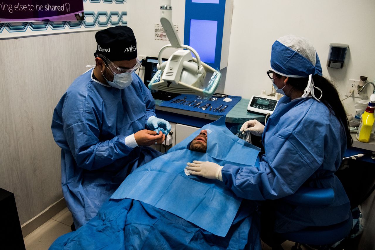 Drs. Fabian Enrique Aguilar Soto and Araceli Pulido begin the surgery of South Dakota’s Brad Cooper at Sani Dental Group’s Platinum center in Los Algodones, Baja California, Mexico, on Oct. 23, 2019. (Ash Ponders for HuffPost)