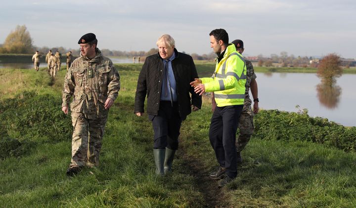 Prime Minister Boris Johnson, centre, walks with Lt Col Tom Robinson from the Light Dragoons and an Environment Agency official, during a visit to see the effects of recent flooding in Stainforth