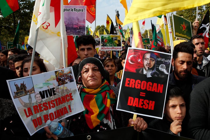 Protesters carrying a sign reading "Erdogan=IS" referring to Turkish President Recep Tayyip Erdogan take part of a demonstration in support of Kurds being targeted by Turkish forces in Syria, on Republique plaza in eastern Paris, Saturday, Oct. 12, 2019.