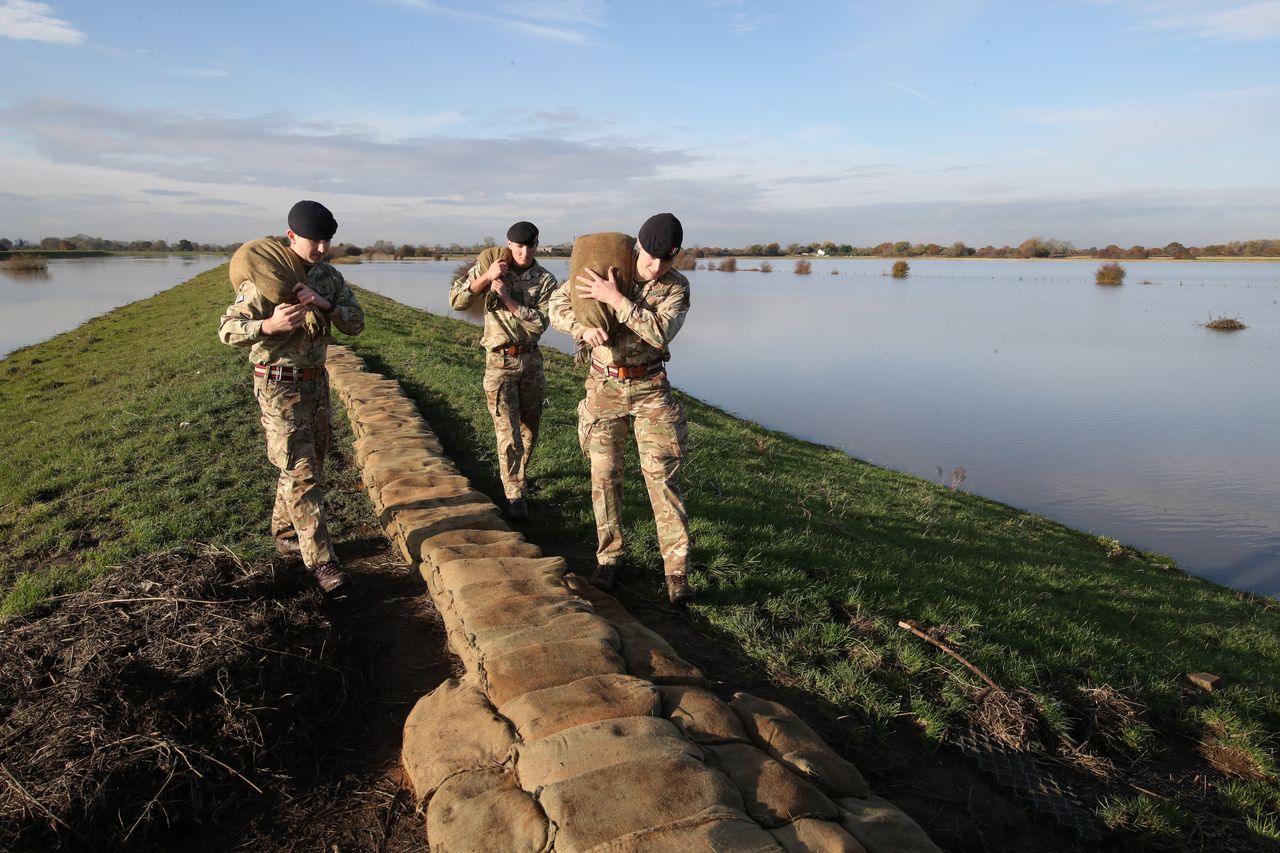 British Army soldiers place sandbags on an embankment at Stainforth