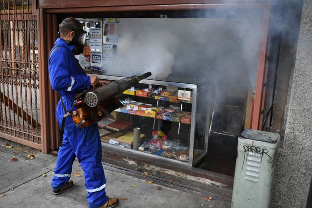 A municipal worker fumigates a store against the aedes aegypti mosquito, vector of dengue fever, Zika...