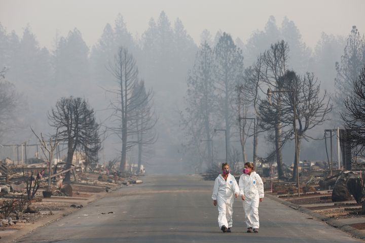 Forensic anthropologists Kyra Stull (L) and Tatiana Vlemincq walk through a trailer park destroyed by the Camp Fire in Paradise, California, on Nov. 17, 2018.