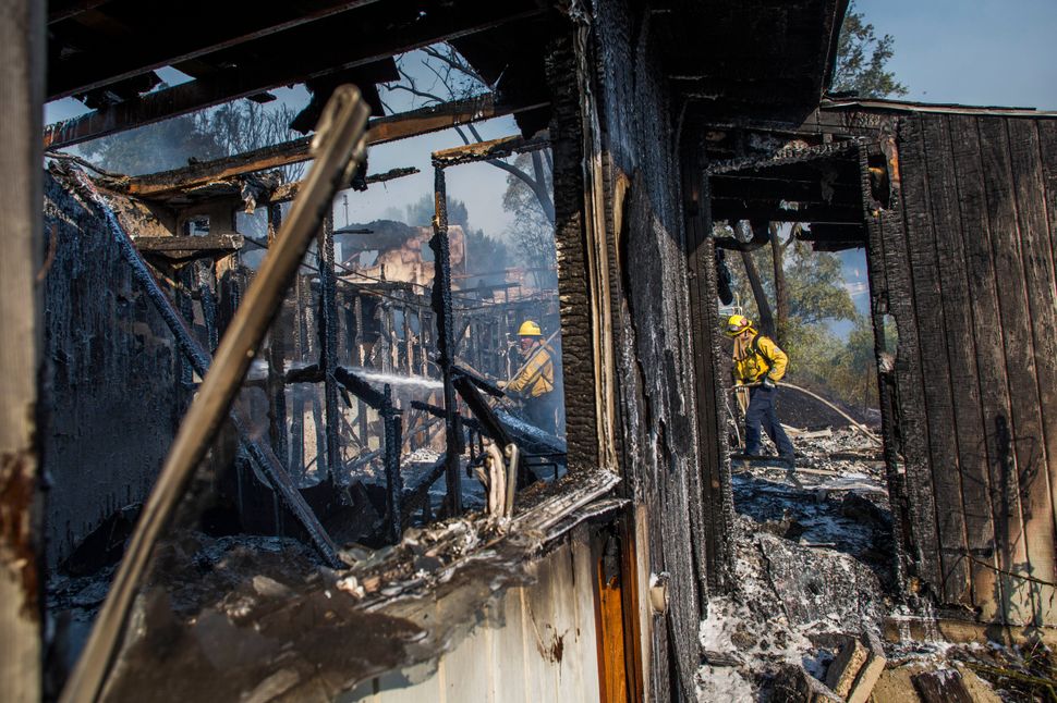Firefighters battle the Getty Fire in houses in Brentwood, California, on 28 October. The wildfire forced widespread evacuations as the flames destroyed several homes in hillside communities.