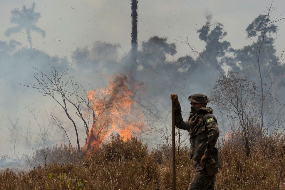 A Brazilian soldier takes a quick rest before resuming firefighting at the Nova Fronteira region in Novo Progresso, Brazil, on 3 September. Brazilian President Jair Bolsonaro sent the military to help extinguish some fires.