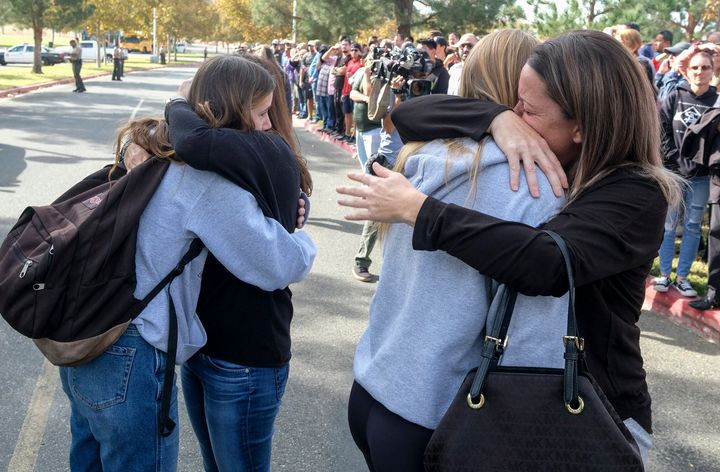 Students are embraced as they reunite at a park following a shooting at Saugus High School that injured several people.