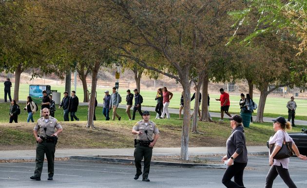 Students are escorted in a line to a park as they wait to be reunited with their parents following a shooting at Saugus High School.