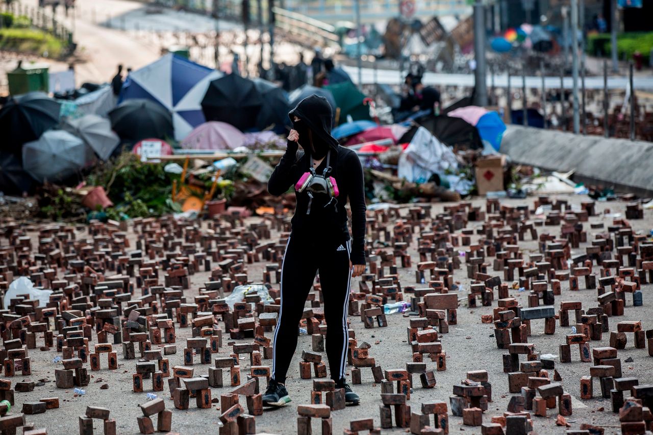 A protester stands amongst bricks placed on a barricaded street outside The Hong Kong Polytechnic University.