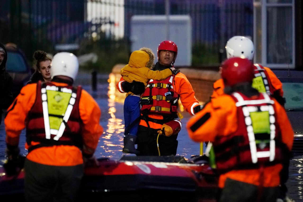 A young child is rescued from their home by a crew from South Yorkshire Fire and Rescue Service after severe flooding on Thursday in Doncaster.