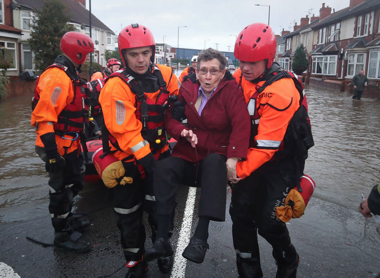 Fire and Rescue service members last week rescue residents trapped by floodwater in Doncaster, Yorkshire, as parts of England endured a month's worth of rain in 24 hours, with scores of people rescued or forced to evacuate their homes, others stranded overnight in a shopping centre, and travel plans thrown into chaos.