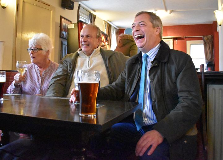 Brexit Party leader Nigel Farage shares a joke with supporters after being bought a pint of bitter by a regular at the Wellington Inn in Eastwood, Nottinghamshire, following a campaign trail walkabout.