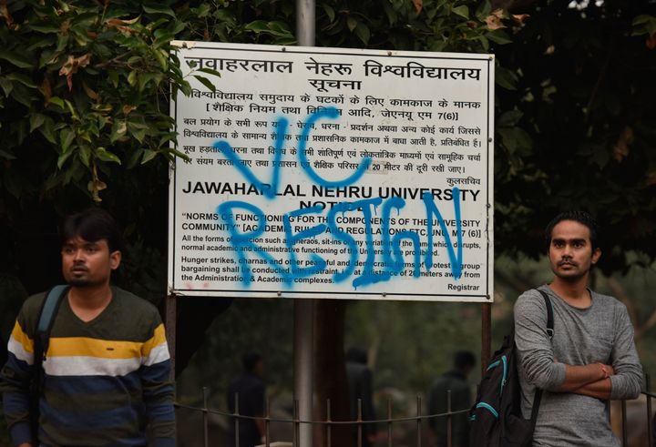 Students stand next to a notice board that has been sprayed with the slogan VC RESIGN, demanding the resignation of the Vice-Chancellor M Jagadesh Kumar, as part of the protests against the administrations move to hike the hostel fee, at JNU, on November 15, 2019. JNUSU said it has received an overwhelming support from more than 150 universities and institutes across the world in its battle against the hostel fee hike.