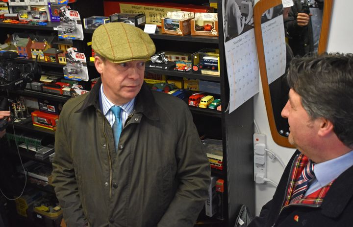Brexit Party leader Nigel Farage chats with a shopkeeper during a walkabout in Eastwood, Nottinghamshire.