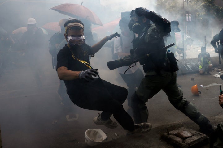 A protester is detained by riot police while attempting to leave the campus of Hong Kong Polytechnic University (PolyU) durin