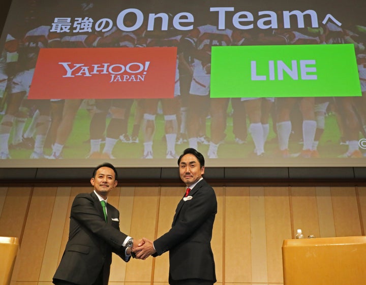 経営統合に関する共同記者会見で握手するZホールディングスの川邊健太郎CEOとLINEの出澤剛CEO＝11月18日、東京都港区