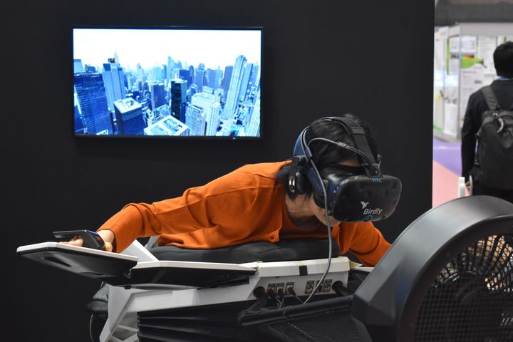 2019年10月に千葉県の幕張メッセで開催された国際展示会『CEATEC』に初出展したソムニアックスが開発したVR機器の『Birdly』を体感する人