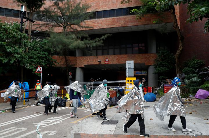 Protesters leave the Hong Kong Polytechnic University campus to surrender to police