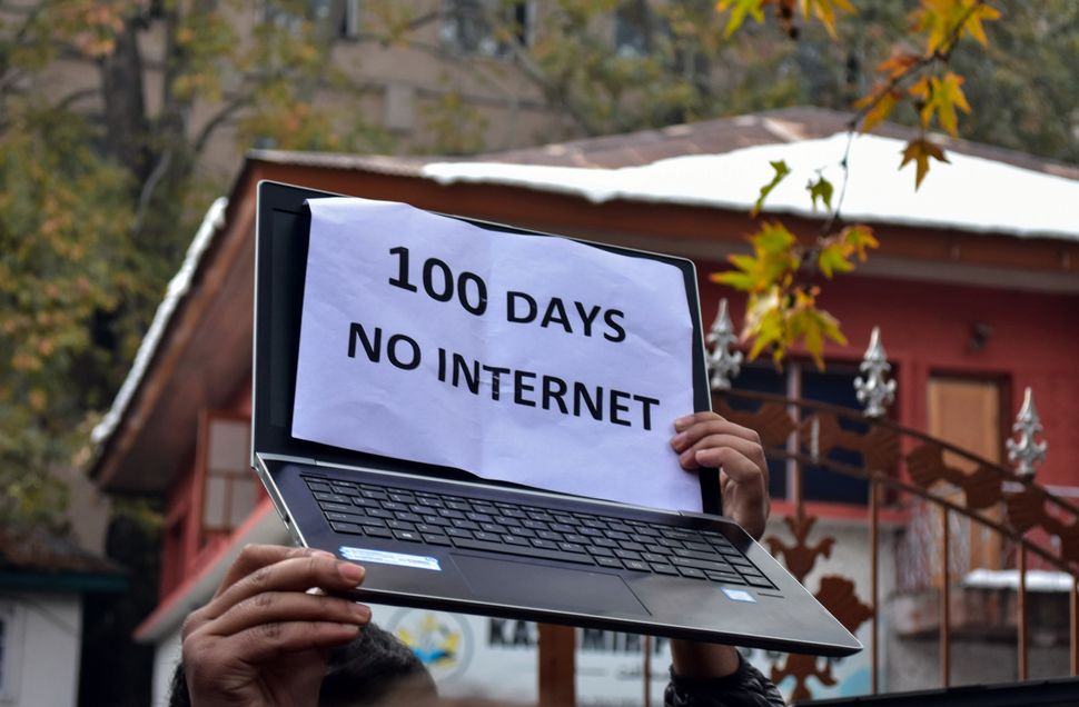 Hands of a journalist holding a laptop and a placard during the protest on 12 November, 2019. 