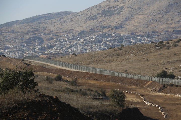 A picture taken on November 19, 2019 shows the Israeli fence separating the Israeli-occupied sector of the Golan Heights and the Druze town of Majdal Shams (background) from Syria (R). 