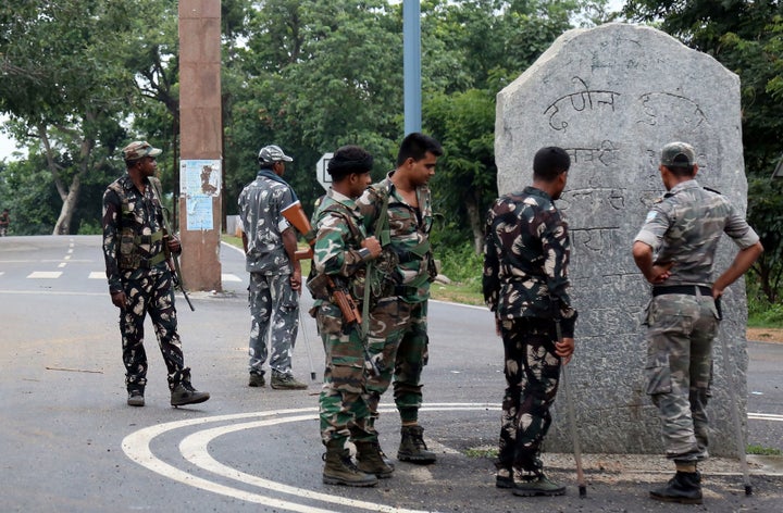 This photo taken on June 26, 2018 shows Indian security forces looking at stone monoliths displaying an allegiance to Pathalgadi -- a popular indigenous tribal movement -- at the entrance to a tribal-dominated region in Khunti district in India's eastern Jharkhand state. 