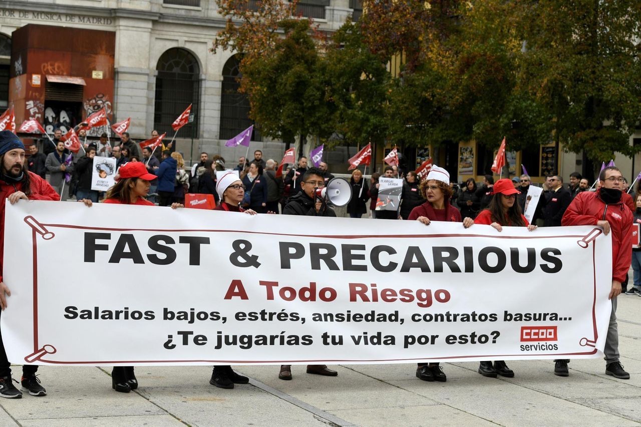 Raúl Calderón, con megáfono en mano, y Javier Godoy (derecha) denuncian junto con otros trabajadores la precariedad del sector de la comida rápida.