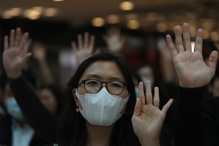 Residents hold up their hands to represent their five demands and chant "Pass the bill, save Hong Kong" at the IFC mall in Hong Kong on Thursday, Nov. 21, 2019. Pressure ratcheted up on Hong Kong as the U.S. Congress approved legislation late Wednesday to sanction officials who carry out human rights abuses and require an annual review of the favorable trade status that Washington grants Hong Kong. Another bill bans export of tear gas and other non-lethal tools to Hong Kong. (AP Photo/Ng Han Guan)