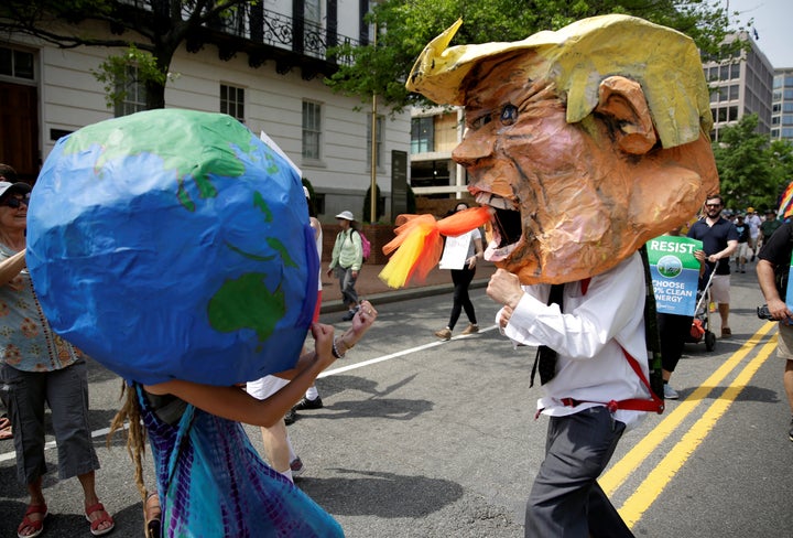 Protesters dressed as the Earth and President Donald Trump pretend to fight during the People's Climate March near the White