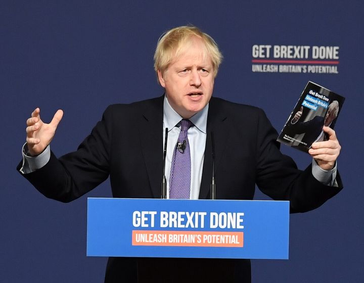 Prime Minister Boris Johnson holds up his party's manifesto during its launch at Telford International Centre in Telford, West Midlands.