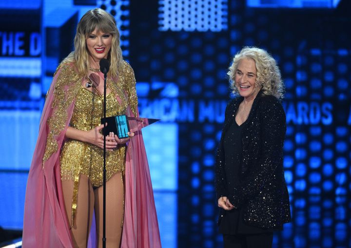 Taylor Swift, left, accepts the award for artist of the decade from Carole King at the American Music Awards on Sunday, Nov. 24, 2019, at the Microsoft Theater in Los Angeles.