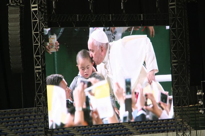 参加者の子供にキスするローマ教皇