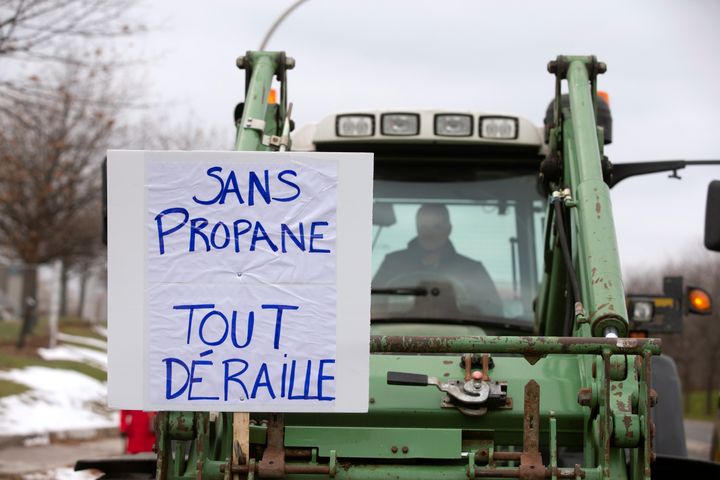 Farmers in tractors with a sign stating "without propane we are all derailed" to protest the lack of propane due to the CN Rail strike in Montreal on Nov. 25, 2019.