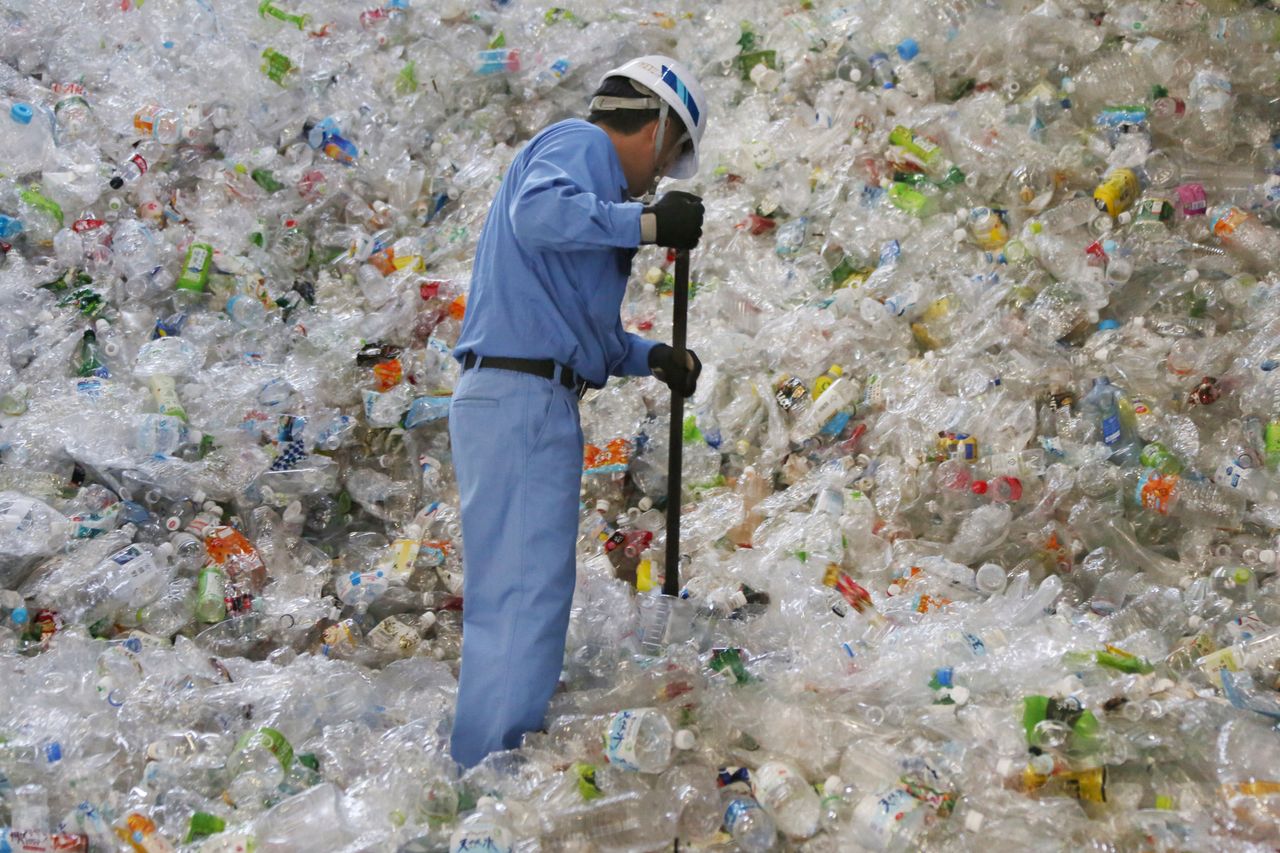 A plastic recycling company worker sorts out plastic bottles in Tokyo. 