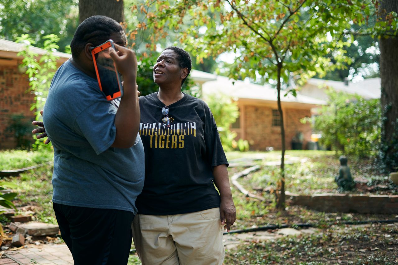 Rosie Phillips talks with her son, J.H., in the backyard at their home in Shreveport.