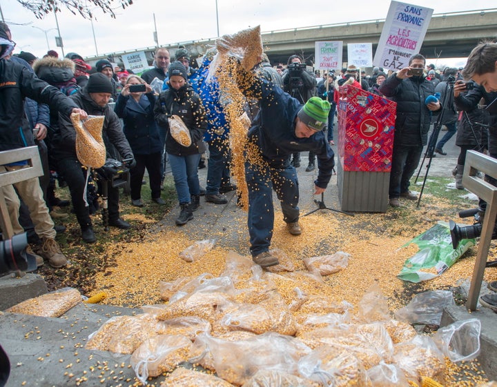 Farmers dump corn as they protest the ongoing rail strike in front of the riding office of Prime Minister Justin Trudeau on Nov. 25, 2019 in Montreal.