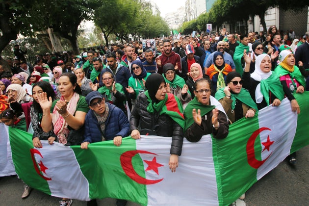 Demonstrators carry national flags and gesture during a protest rejecting the December presidential election...