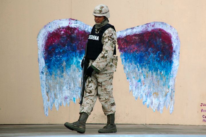 Ένας στρατιώτης περνά μπροστά από ένα graffitti που απεικονίζει τα «φτερά αγγέλου» της γνωστής καλλιτέχνιδος Κολέτ Μίλλερ (Μεξικ, 18 Μαρτίου 2015).
