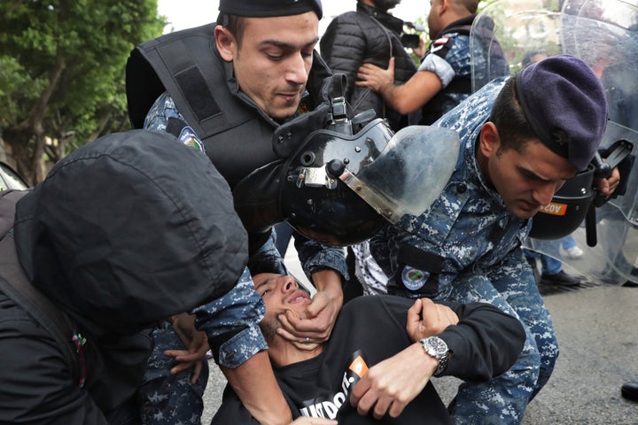 Riot police scuffle with anti-government protesters blocking a road in Beirut, Lebanon, Monday, Nov. 25, 2019. 