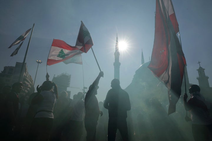 Anti-government protesters wave Lebanese national flags as gather during separate civil parade at the Martyr square, in downtown Beirut, Lebanon, Friday, Nov. 22, 2019. 